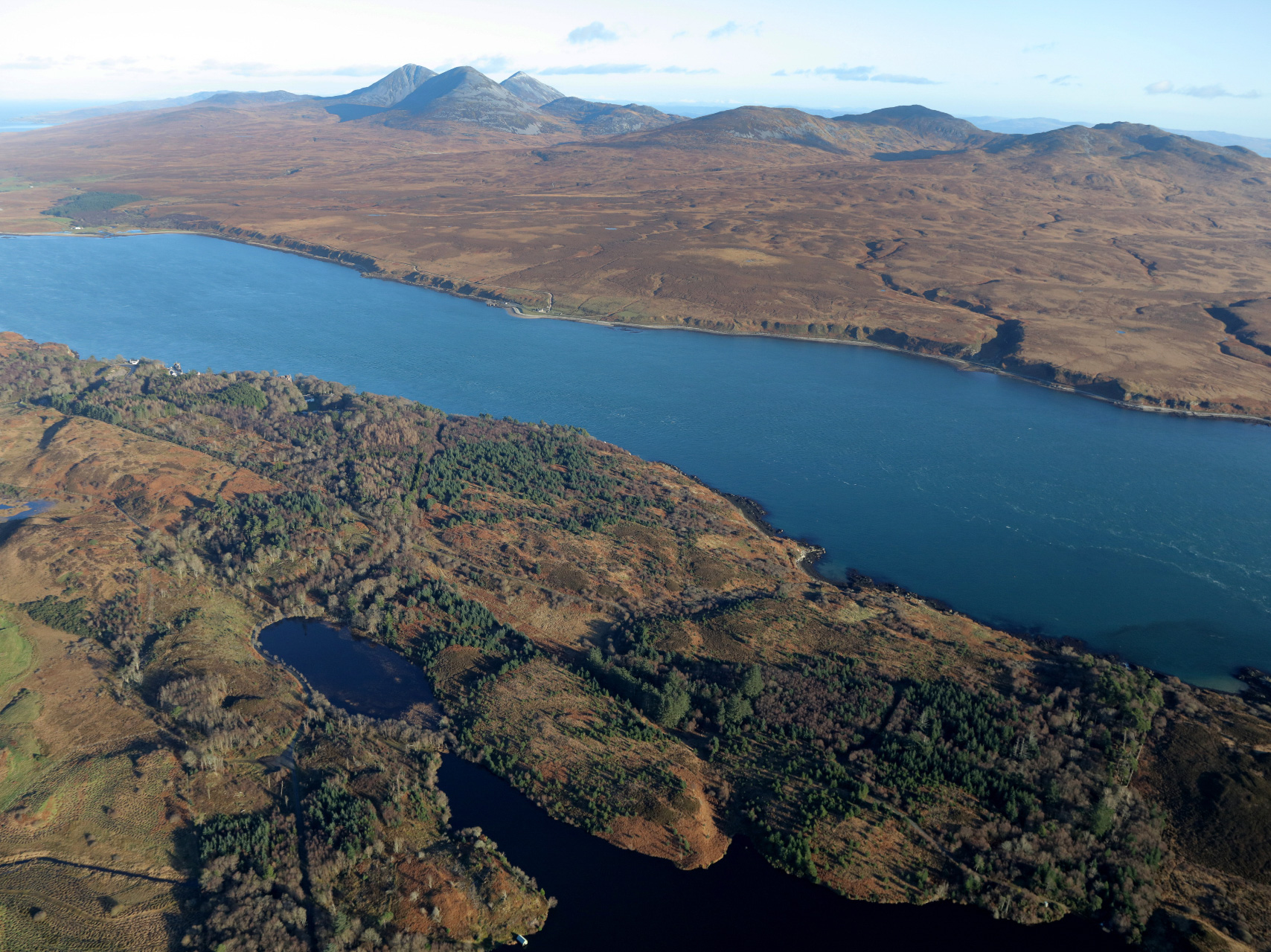 An aerial shot of Islay in the foreground and Jura in the background with the Sound of Islay inbetween