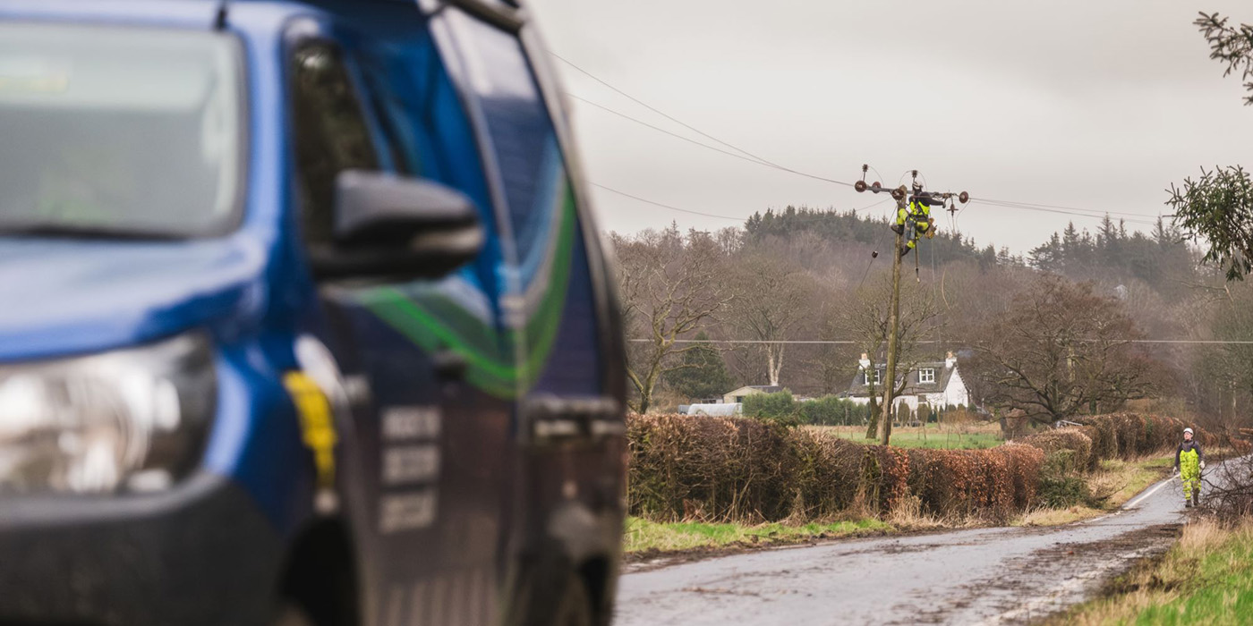 An SSEN vehicle drives past a repair being carried out on the network up a pole