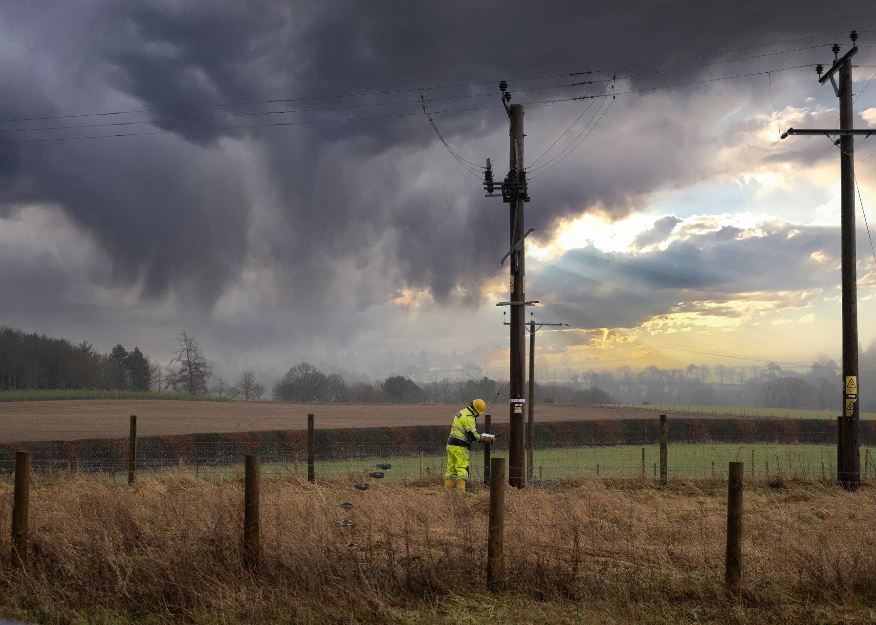 SSEN engineer inspecting a pole in a field