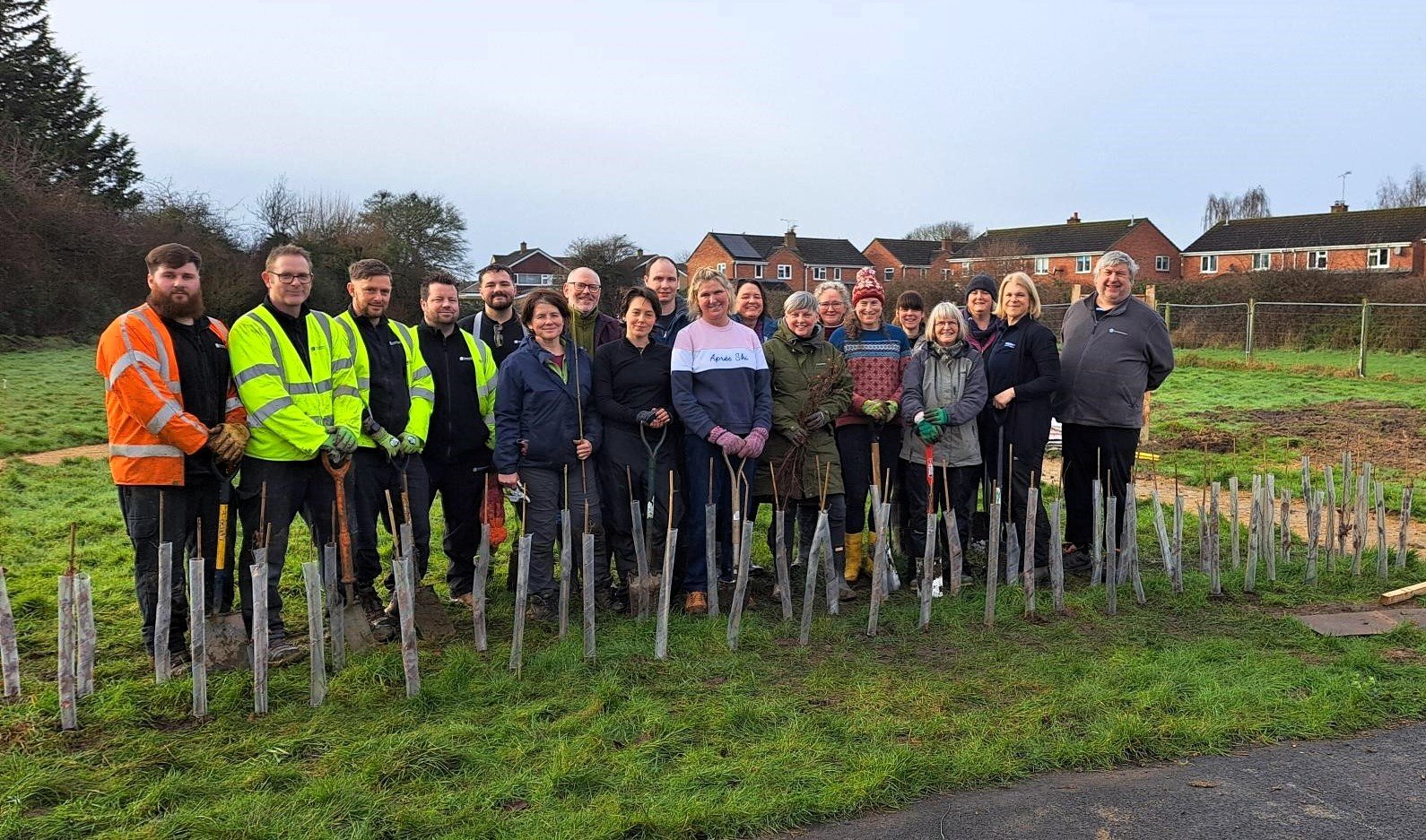 Group of people in garden with newly planted trees