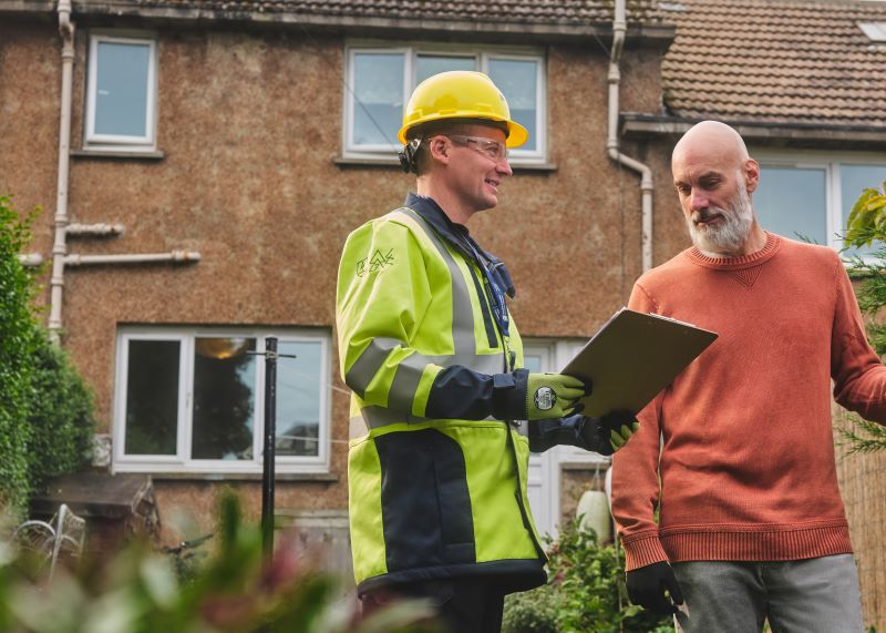 An SSEN team member advises a member of the public in their garden