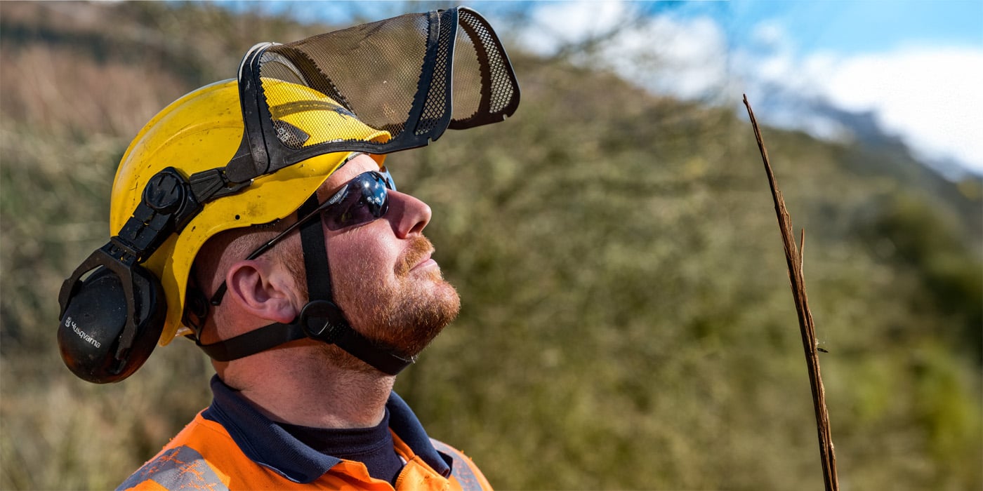 Man in hard hat and visor looking at sunny sky