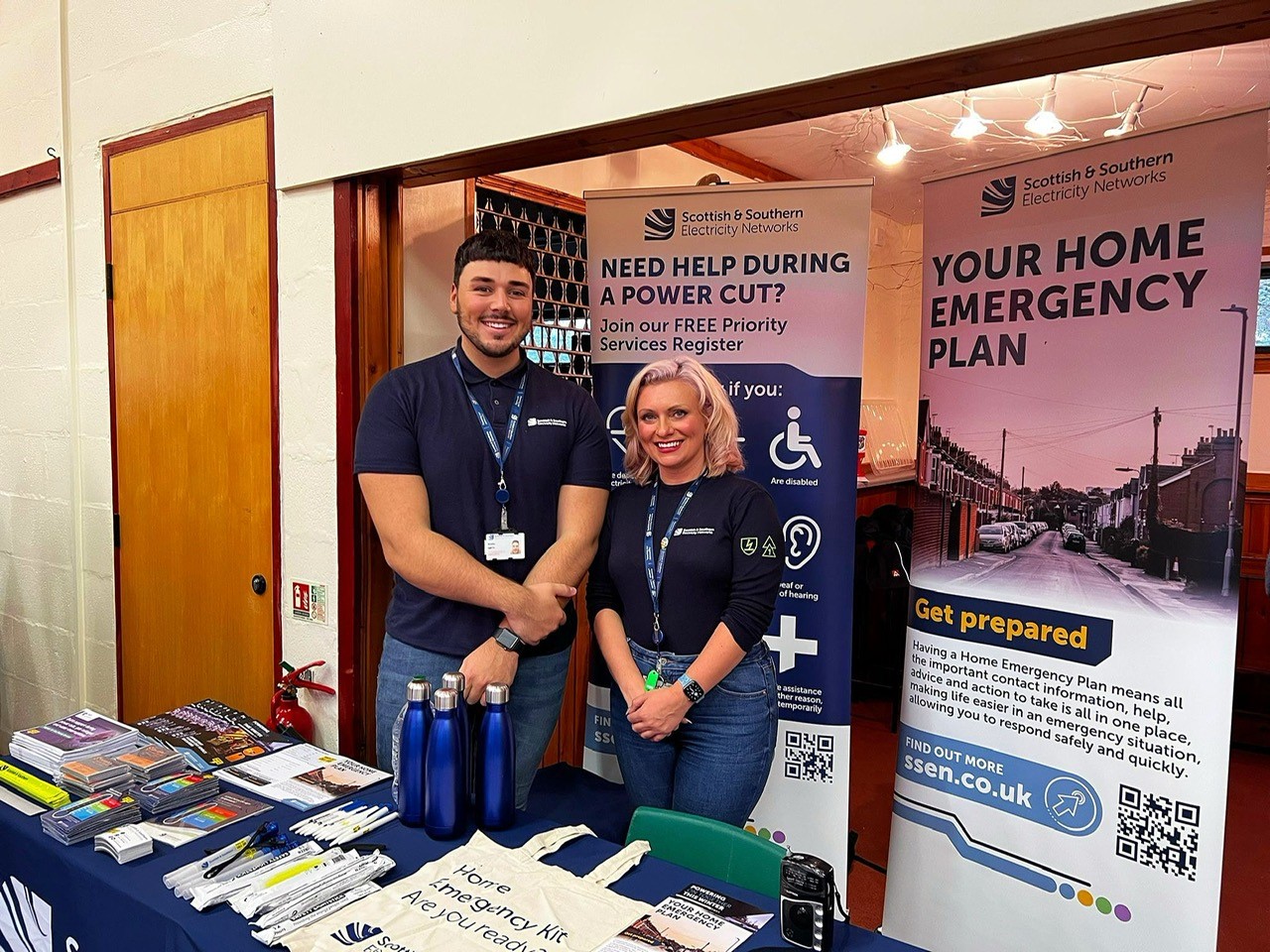 Bradley and Samantha from SSEN standing at an SSEN resilience stand at Glenisla Hall