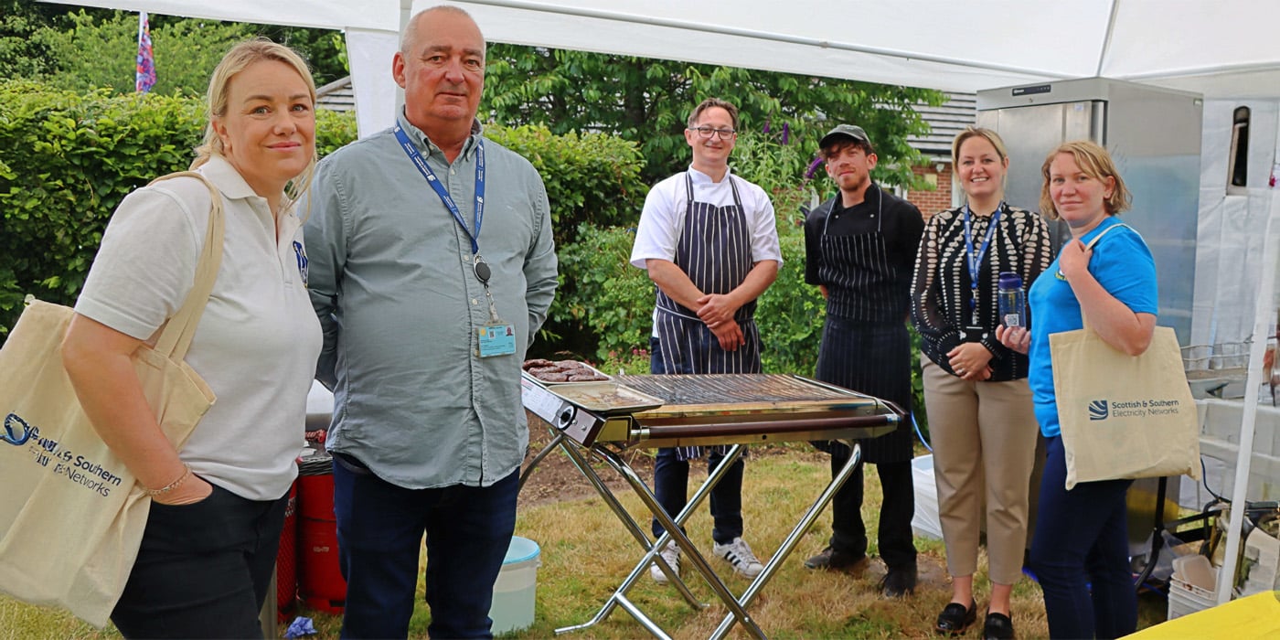 People inside marquee with chefs and BBQ