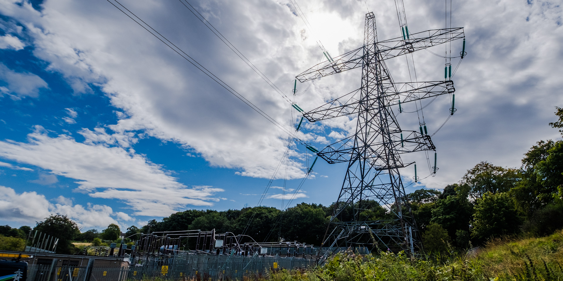 An image of the grid supply point at Bridge of Don - a large electricity tower is high above the head of the photographer