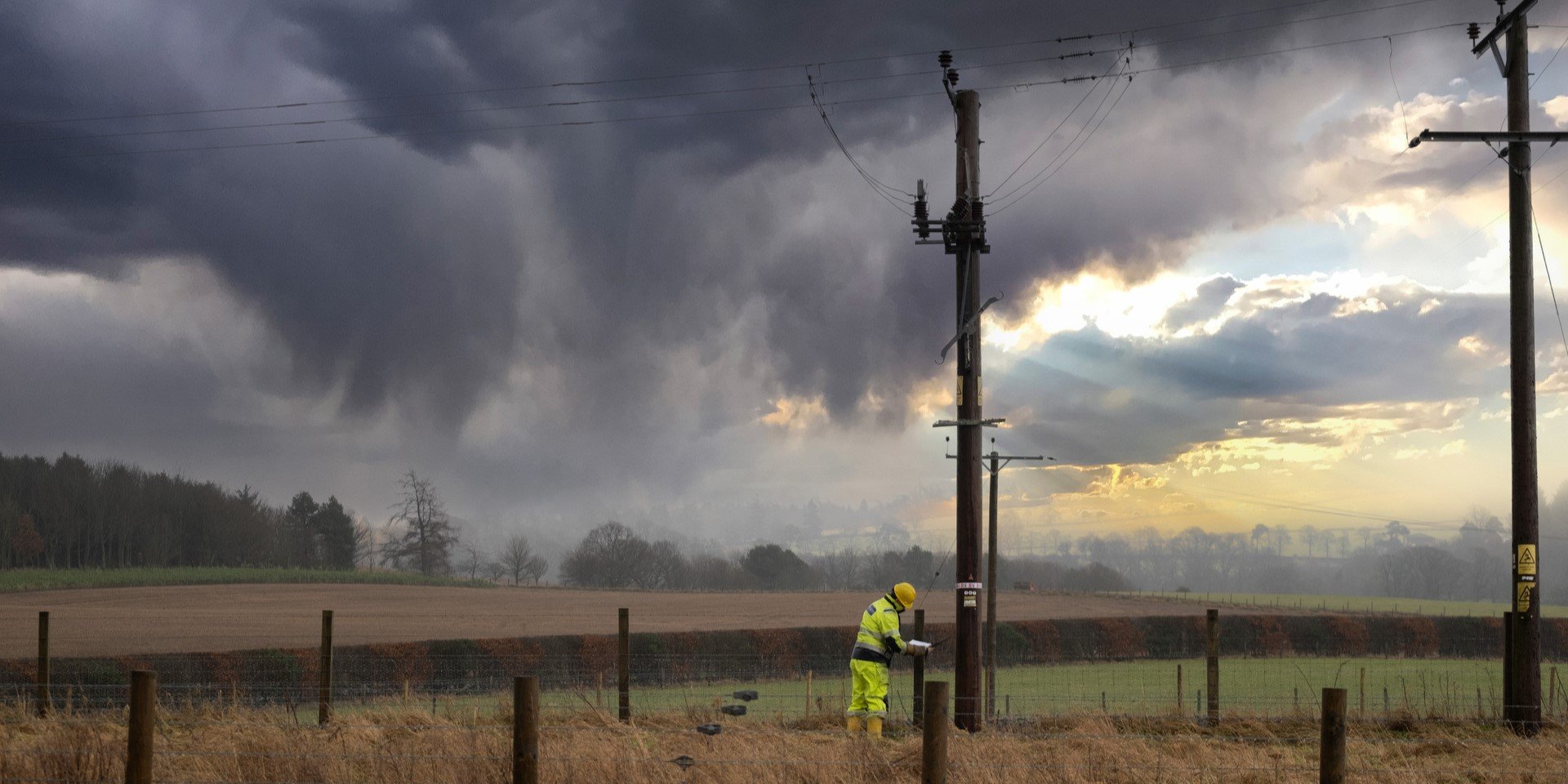 An SSEN engineer inspecting a pole in a field