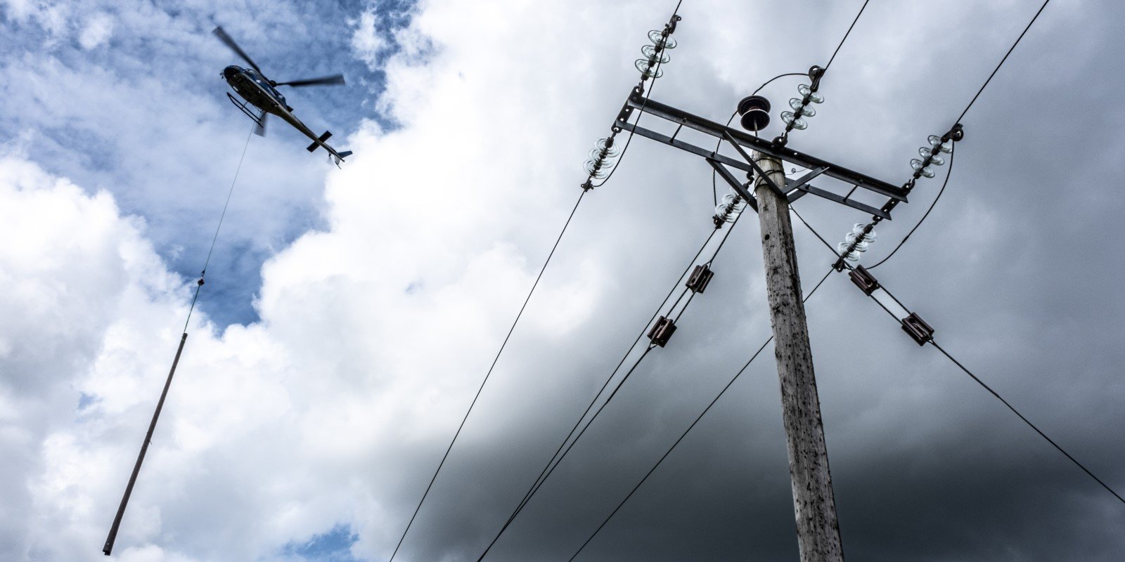 Distribution network infrastructure being renewed with a picture of a helicopter delivering a new pole