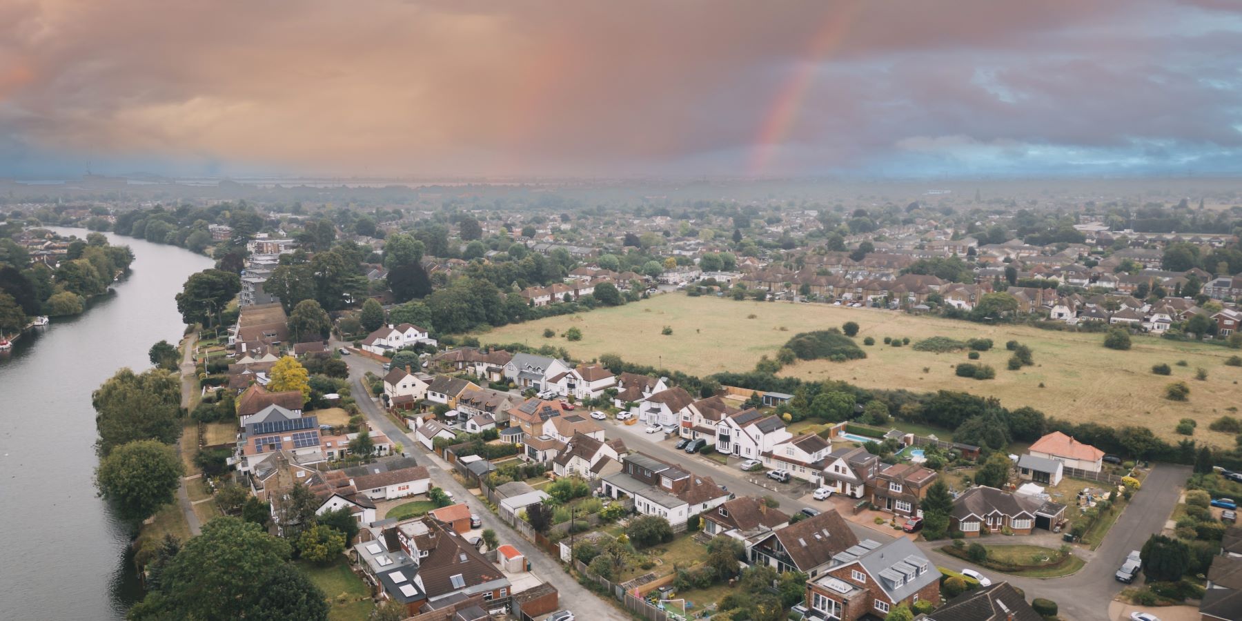 An aerial view of Reading with the river on the left and a rainbow in the sky